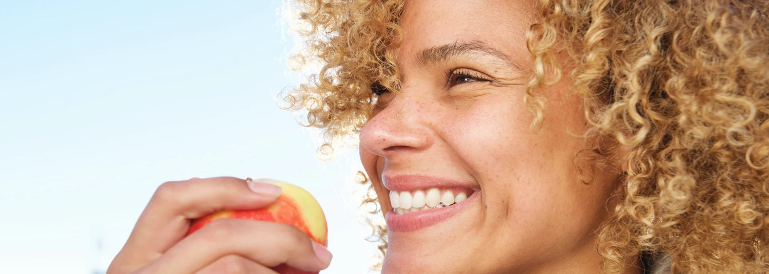 Woman smiling holding an apple