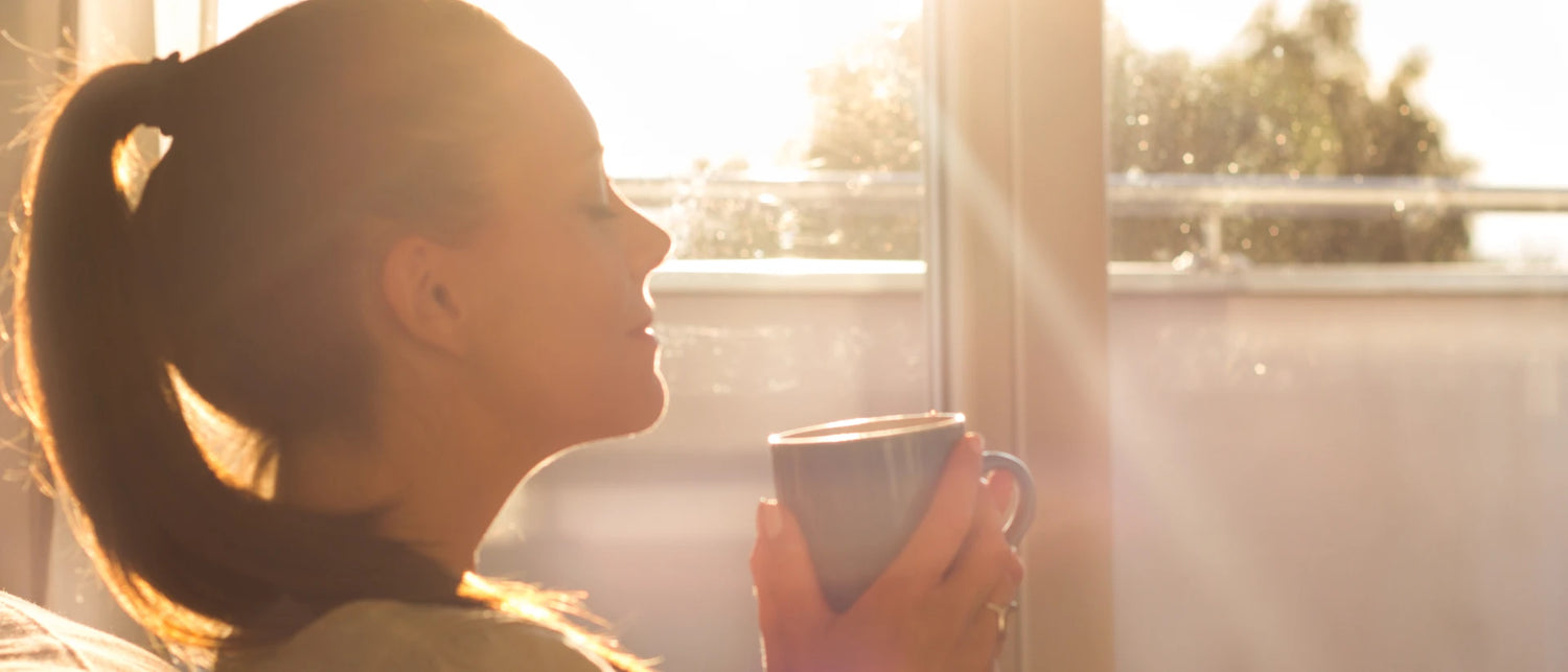 Woman holding mug with eyes closed