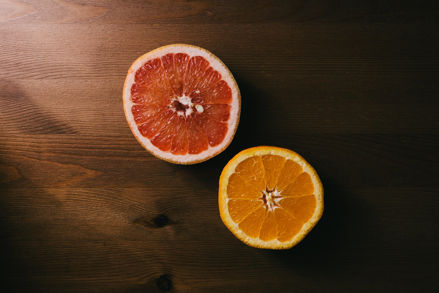 Slice of an orange and grapefruit on wood board